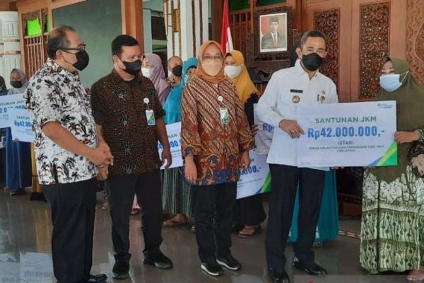 Bupati Pati Haryanto didampingi Kepala BPJAMSOSTEK Cabang Kudus Multanti menyerahkan santunan kepada ahli waris dari nelayan yang menjadi peserta jaminan sosial ketenagakerjaan secara simbolis di Pendopo Kabupaten Pati, Jawa Tengah, Kamis (20/1/2022). (HO-BPJS Ketenagakerjaan Cabang Kudus)